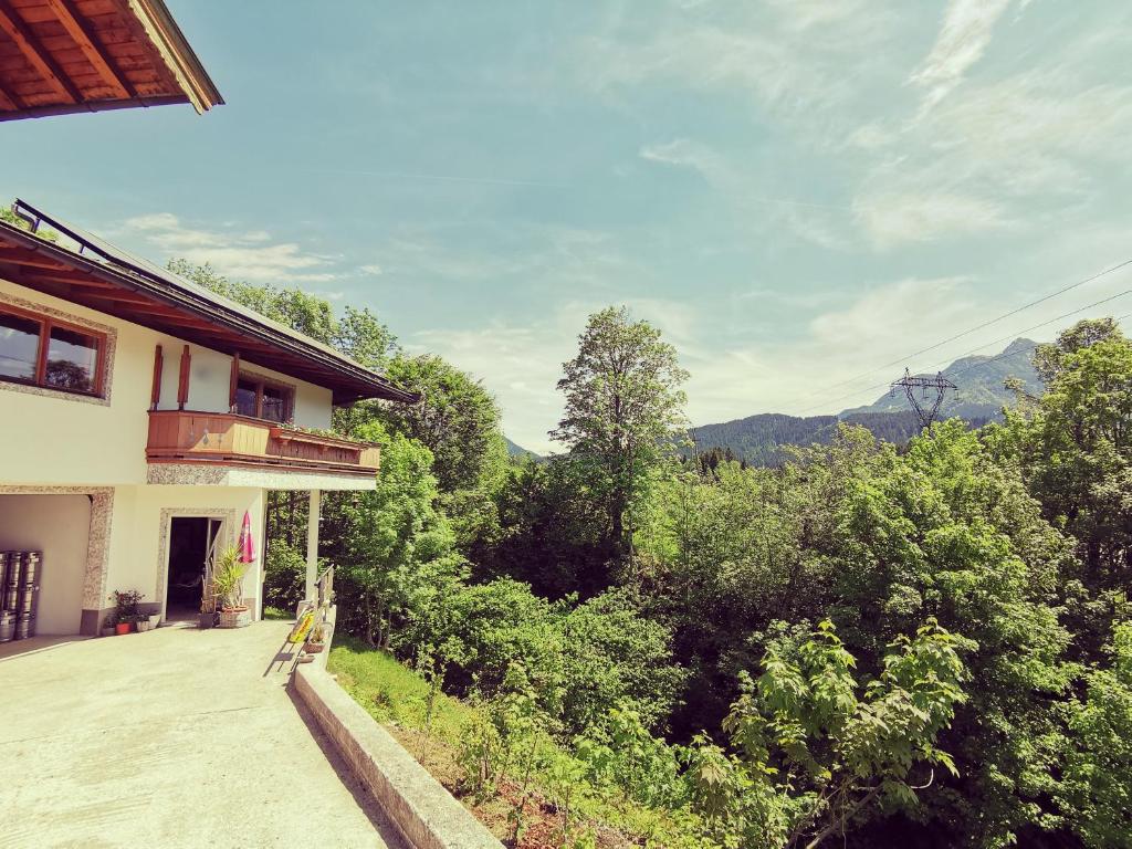 a view of a house with a balcony and trees at Ferienwohnung Grabner in Fieberbrunn