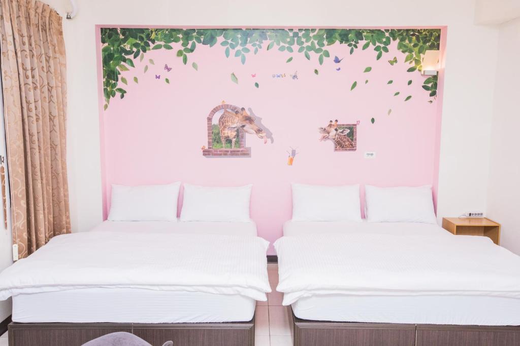 two beds in a room with leaves on the wall at 1986 Travel Hall in Anping