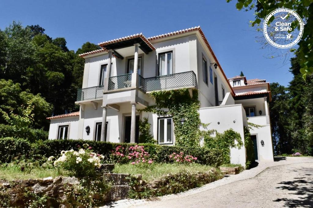 Una casa blanca con hiedra a un lado. en Eighteen21 Houses - Quinta Velha, en Sintra