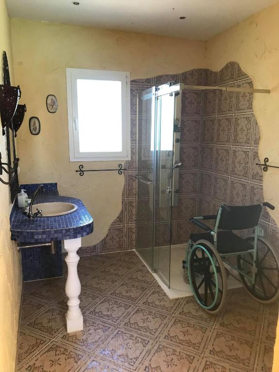 La salle de bains est pourvue d'une douche et d'un fauteuil roulant. dans l'établissement Sud Vacances, à Montels