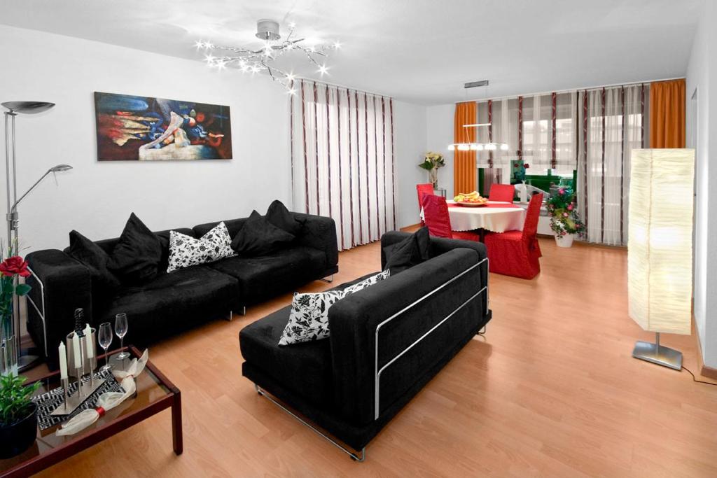 a living room with a black couch and a table at Business Suiten in Bochum