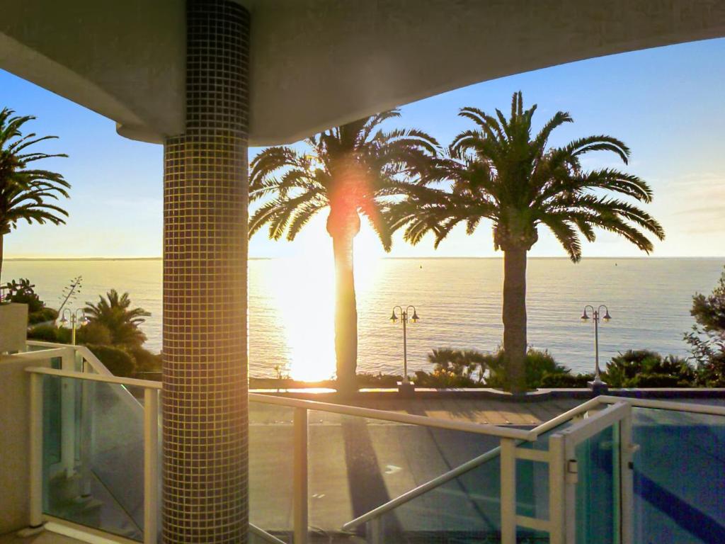 Blick auf das Meer und die Palmen von einem Gebäude aus in der Unterkunft Bright apartment in Alcanar with sea and mountain views in Les Cases d'Alcanar