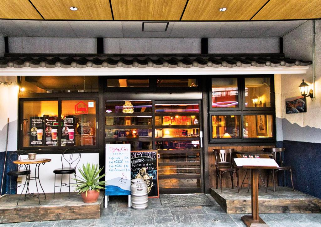 - un restaurant avec des tables et des chaises à l'intérieur dans l'établissement DJANGO Hostel & Lounge, à Tanabe