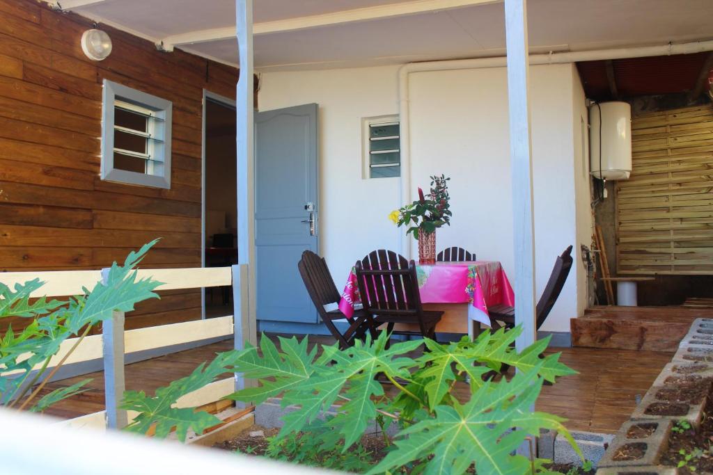 un patio con 2 sillas y una mesa en un porche en Maison d'une chambre avec vue sur la mer jardin clos et wifi a Petite Ile a 2 km de la plage, en Petite Île