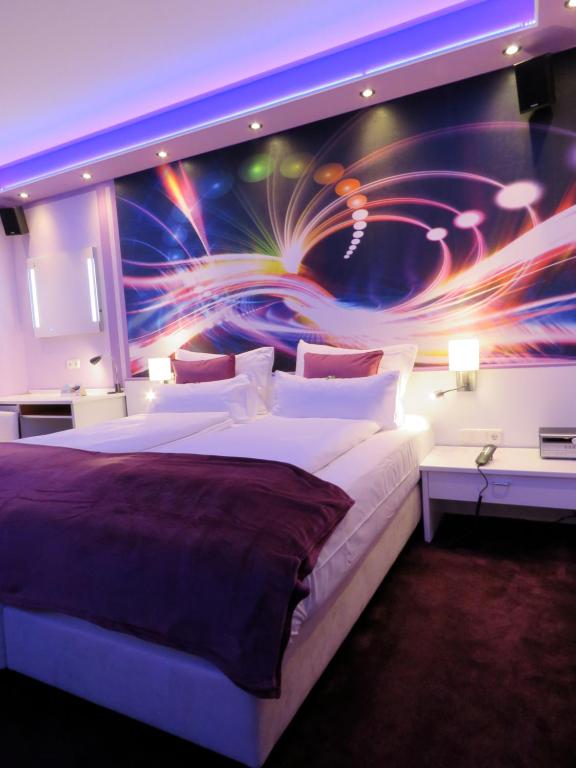 - une chambre avec un grand lit orné d'une peinture murale dans l'établissement Hotel Residenz Hössinger, à Sankt Pölten