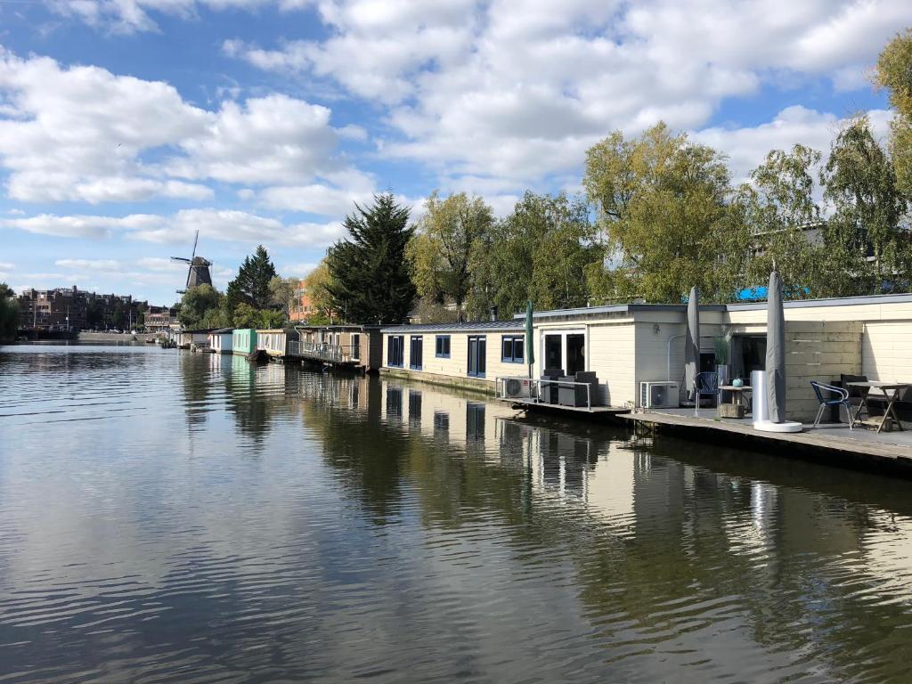 einen Fluss mit Häusern an der Seite in der Unterkunft Luxury studio on Robs houseboat special for couples in Amsterdam