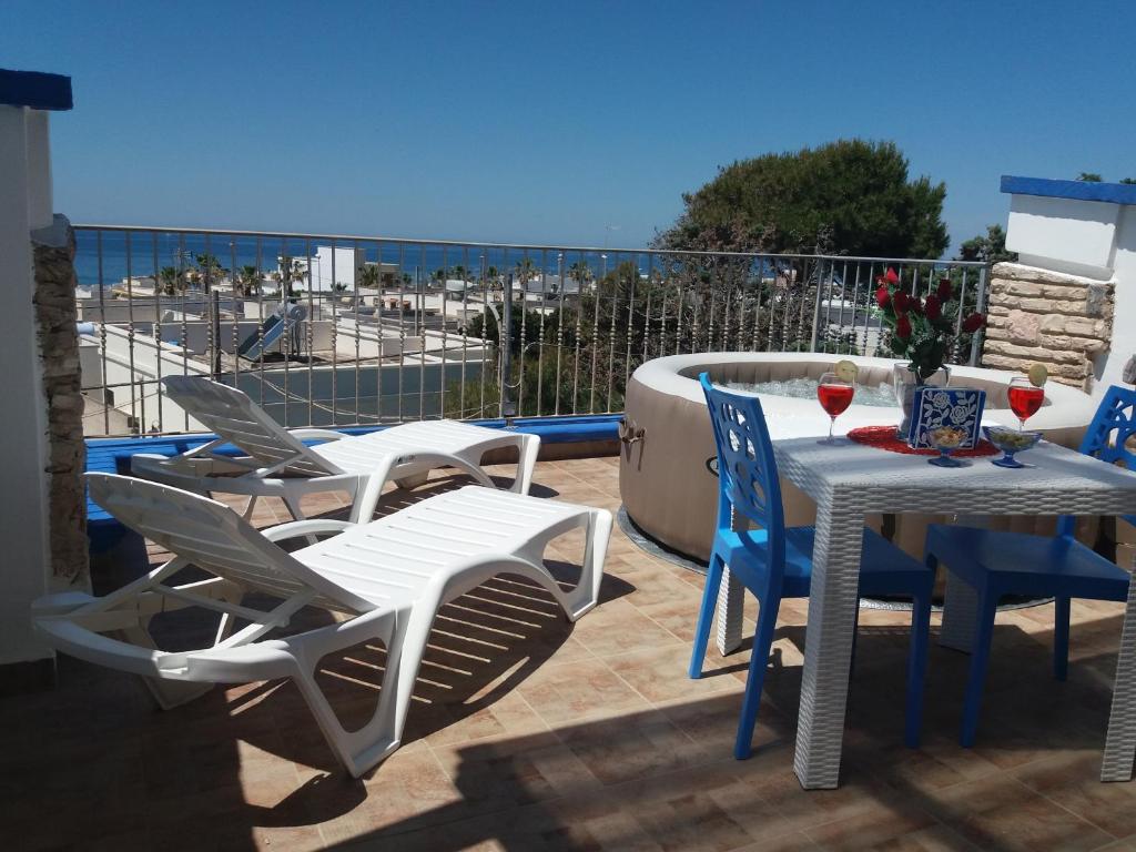 un patio con mesa y sillas y vistas al océano en Riflesso sul mare, en Marina di Mancaversa