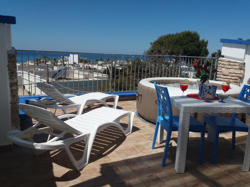 un patio con tavolo, sedie e vista sull'oceano di Riflesso sul mare a Marina di Mancaversa