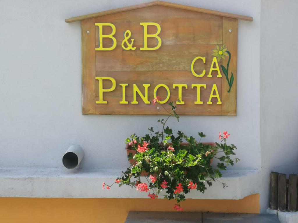 a sign on the side of a building with a plant at Cà Pinotta in Miazzina