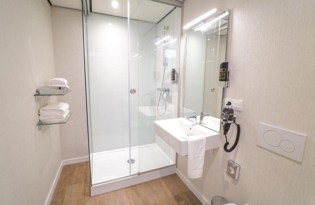 a bathroom with a sink, mirror, and toilet at The Fallon Hotel Alkmaar in Alkmaar