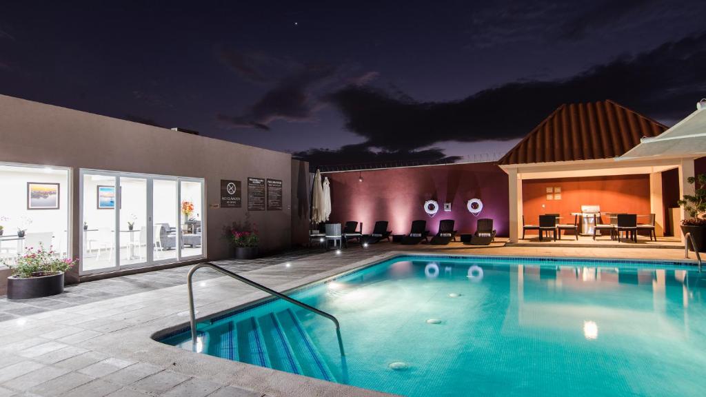 a large swimming pool in front of a building at Candlewood Suites - Queretaro Juriquilla by IHG in Querétaro