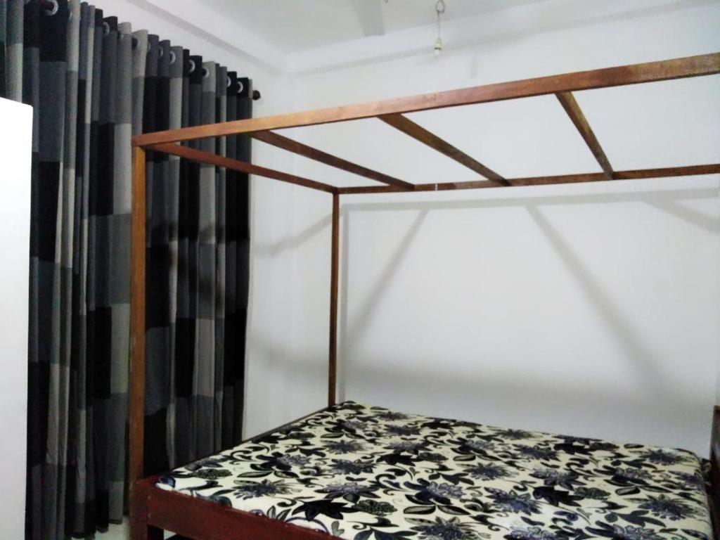 a bunk bed with a black and white curtain at Villa44 in Hikkaduwa