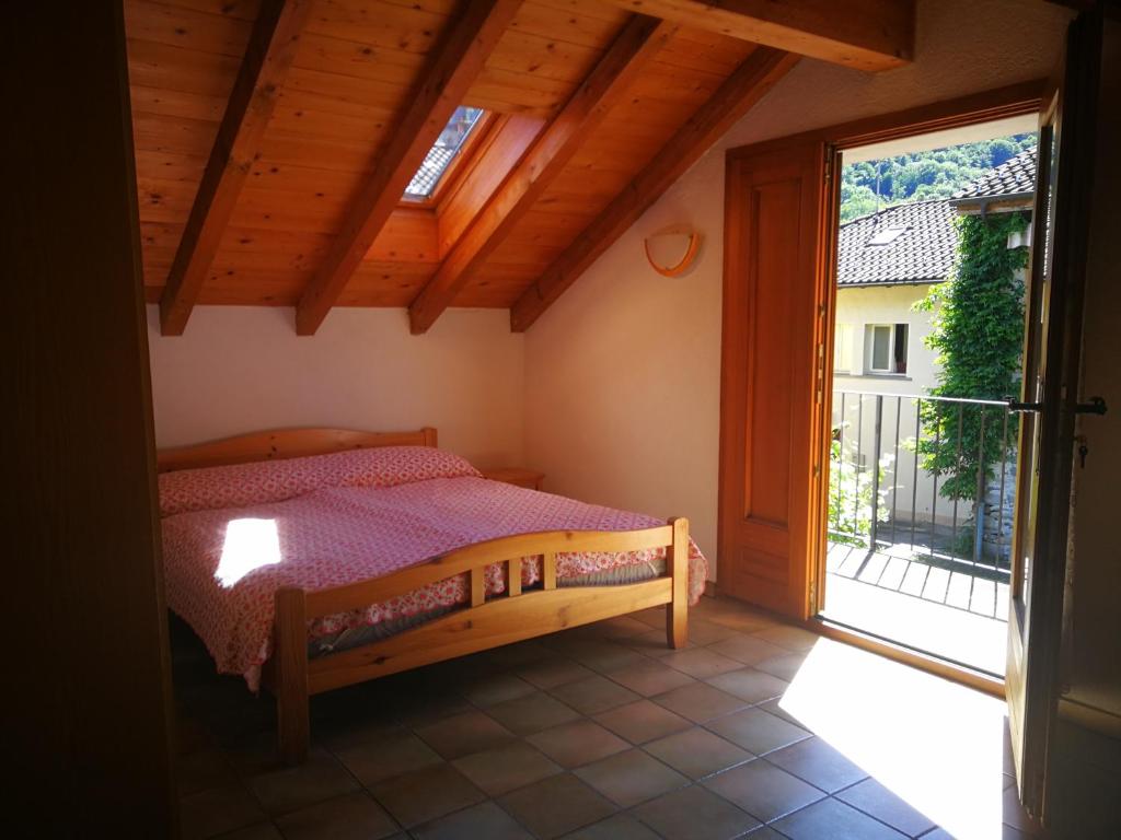 a bedroom with a bed and a large window at Rustico Il Pardo in Maggia