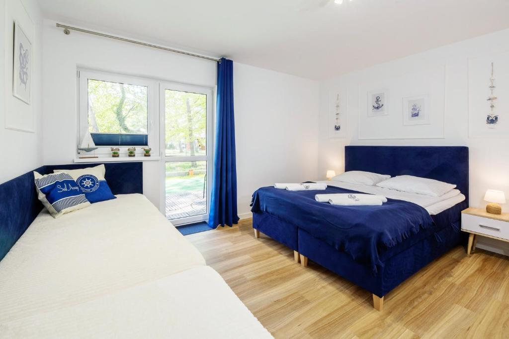a bedroom with two beds and a window at Apartament 4B Blue Marine Poddąbie in Poddąbie