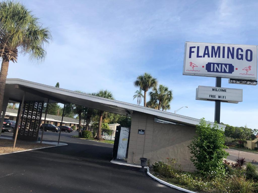 um posto de gasolina com um sinal para uma pousada flamingo em Flamingo Inn em Sarasota