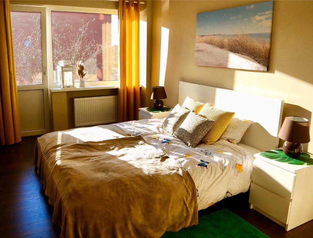 um quarto com uma cama grande em frente a uma janela em Neptune Ear, Family-friendly, modern, fully-equipped, cozy apartment em Ventspils