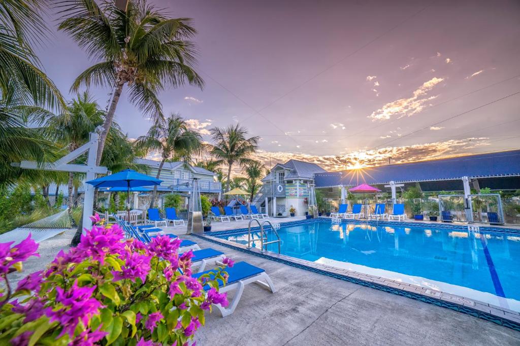 a pool at a resort with purple flowers and palm trees at Ibis Bay Resort in Key West