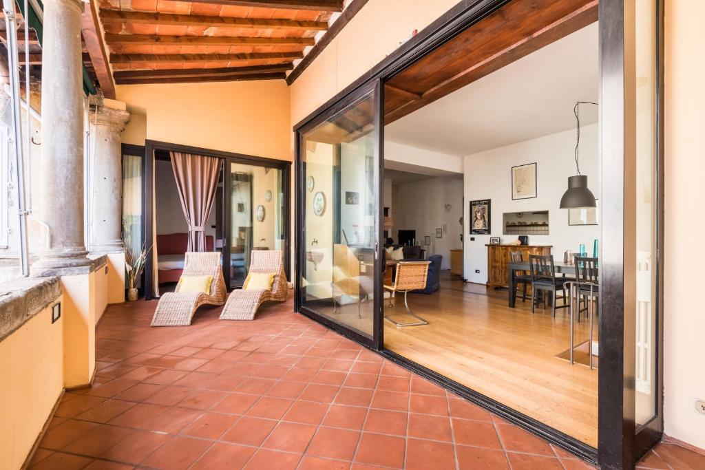 ein offenes Wohnzimmer mit Glastüren und ein Esszimmer in der Unterkunft Refined flat with private loggia in San Frediano in Florenz