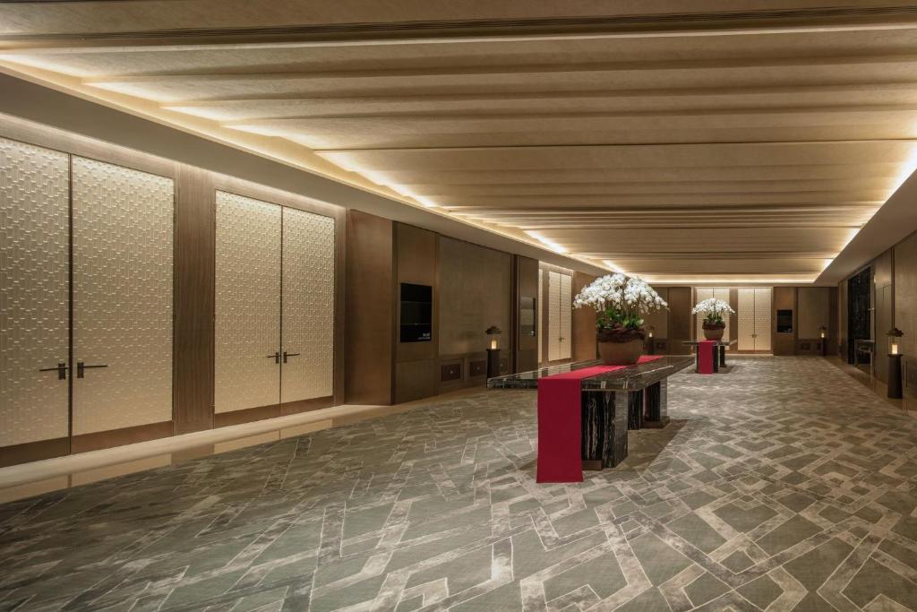 重慶的住宿－重庆丽晶酒店，洲际酒店集团旗下，带有桌子和鲜花的建筑走廊