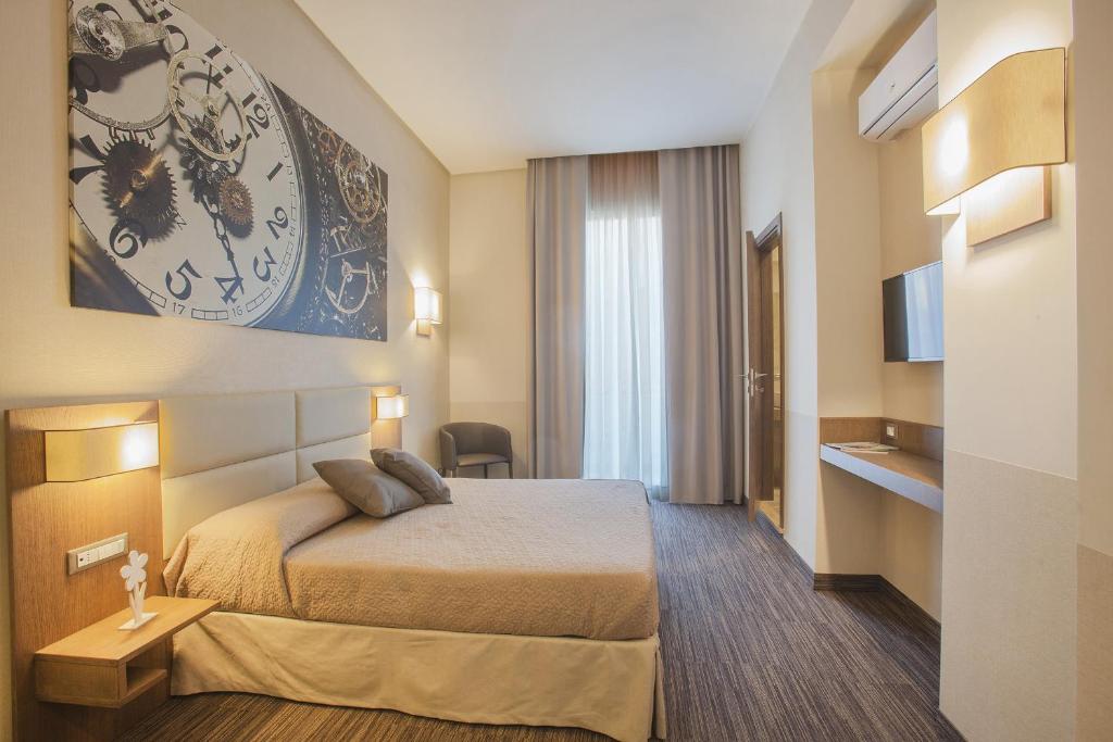 ナポリにあるB&B Dimora San Feliceのベッド1台と壁掛け時計が備わるホテルルームです。