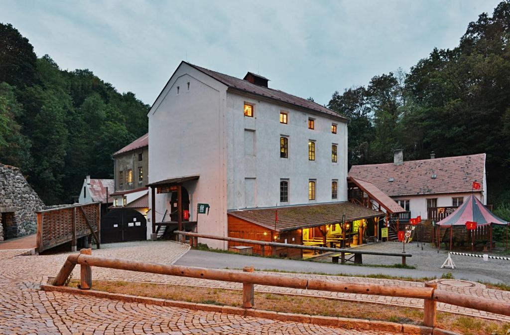 un grand bâtiment blanc situé à côté d'un bâtiment dans l'établissement Housův Mlýn, à Tábor