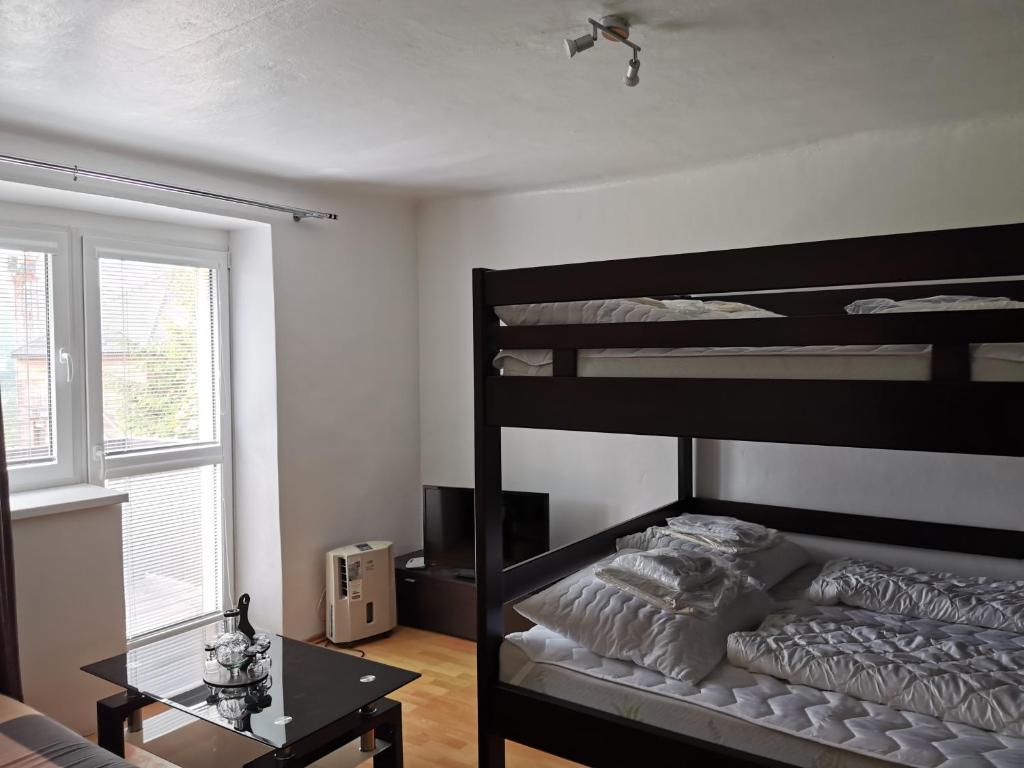 sypialnia z 2 łóżkami piętrowymi i stołem w obiekcie Apartmán Romance w mieście Lipno nad Vltavou