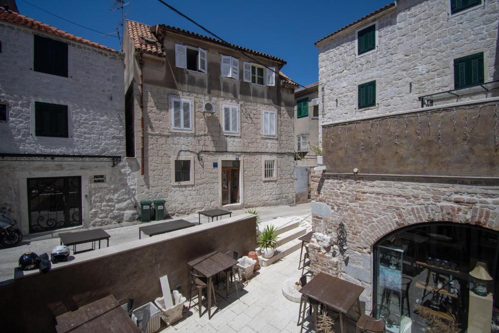 eine Gasse in einem alten Steingebäude mit Tischen und Stühlen in der Unterkunft Apartment Kira in Split
