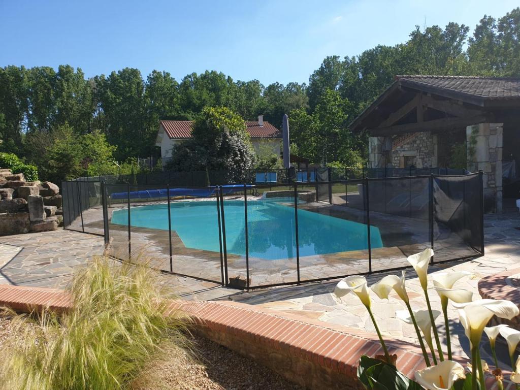 una piscina con una valla alrededor en Les Genets, en Orléat