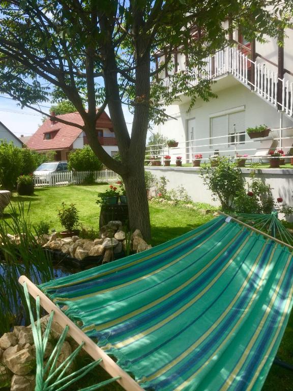 a hammock in the yard of a house at Lelle-kert Apartman 02 in Balatonlelle