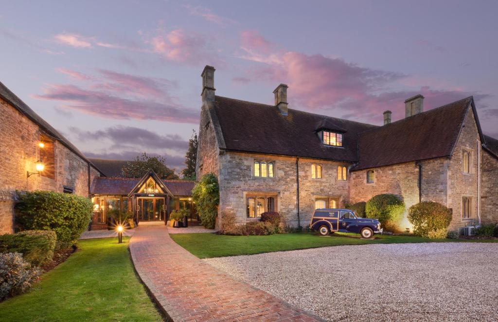 um carro velho estacionado em frente a uma casa em voco Oxford Thames, an IHG Hotel em Oxford