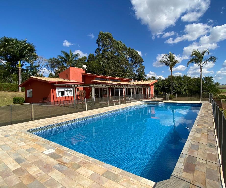 a swimming pool in front of a house at Sitio Pedacinho do Céu in Bragança Paulista