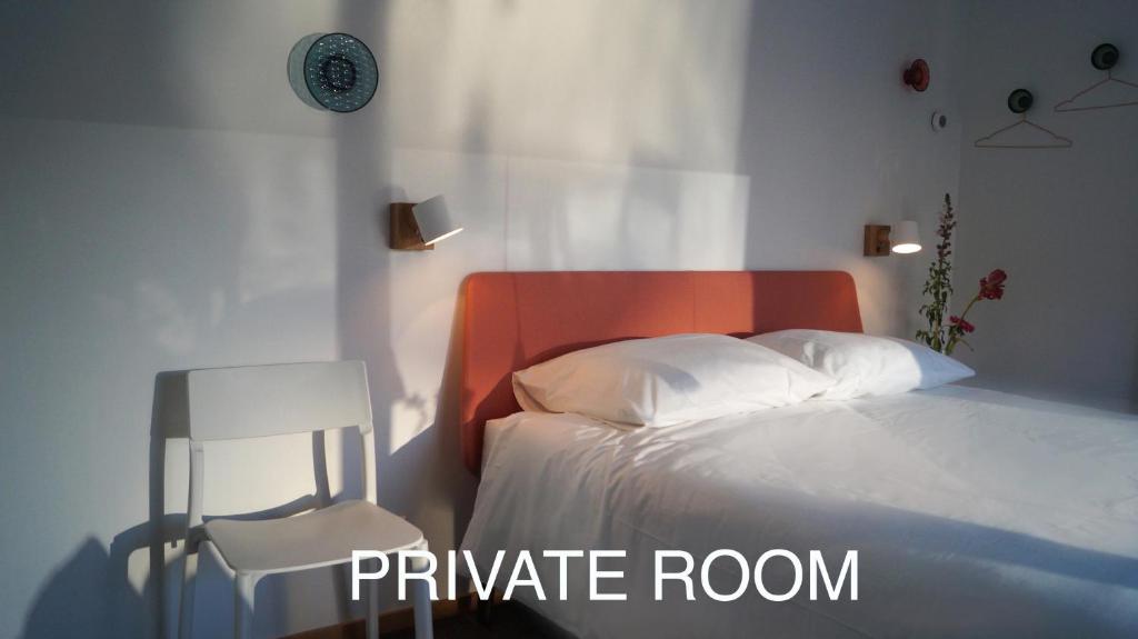 a bedroom with a white bed with an orange headboard at Room With A Few in Amsterdam