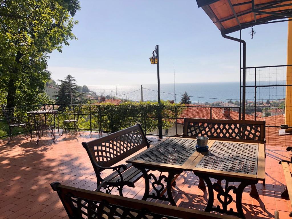 - une table et des chaises sur une terrasse avec vue sur l'océan dans l'établissement ESPERIA casa vacanza, à Trieste