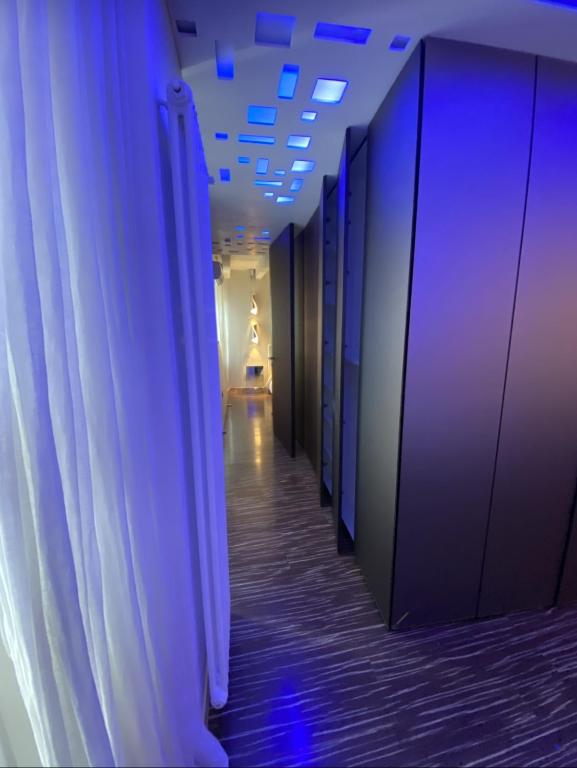 a hallway with blue lights on the walls at Welcome Traveller ATMOSPHERE APARTMENT in Bardolino
