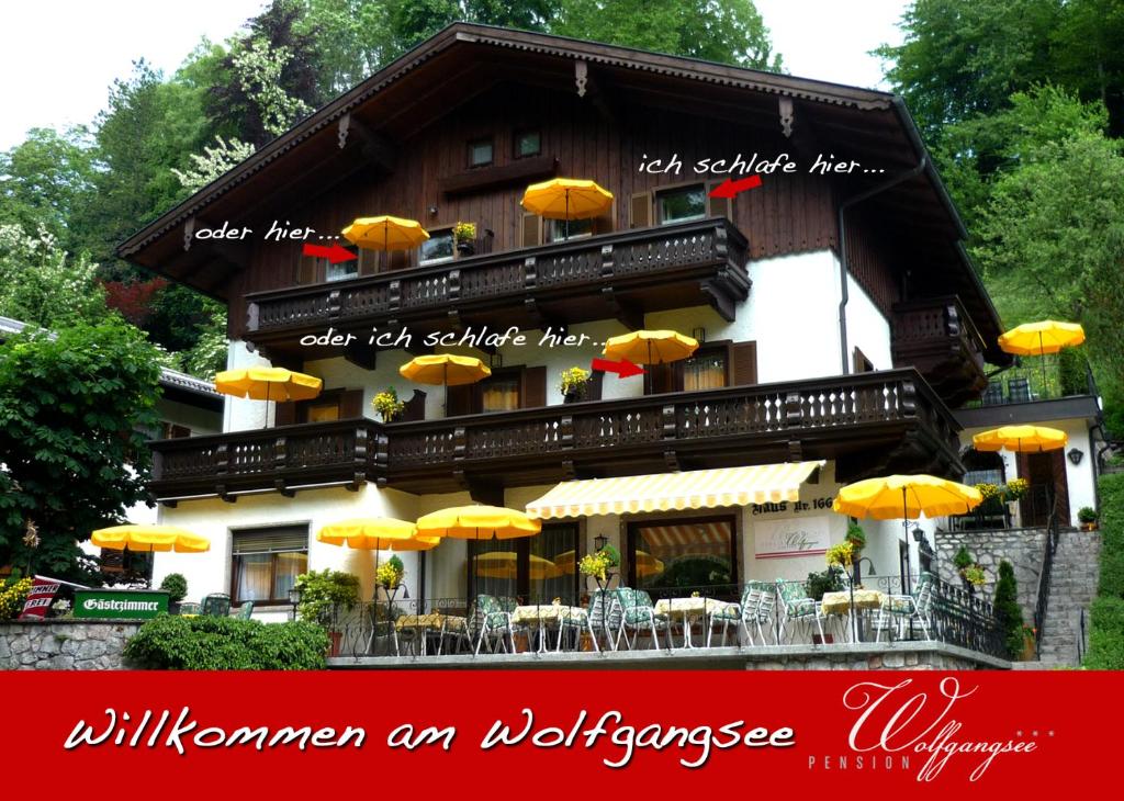 ein Gebäude mit gelben Sonnenschirmen davor in der Unterkunft Pension Wolfgangsee in St. Wolfgang