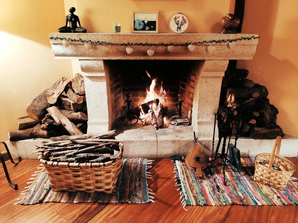 a fireplace in a living room with a fire at Posada de Candelario in Candelario