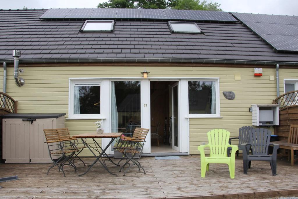 eine Terrasse mit Stühlen und einem Tisch vor einem Haus in der Unterkunft Journal aux Lacs-5pers in Froidchapelle