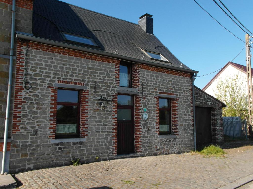 a brick house with a black roof at La Maison d'Aldegonde in Beloeil