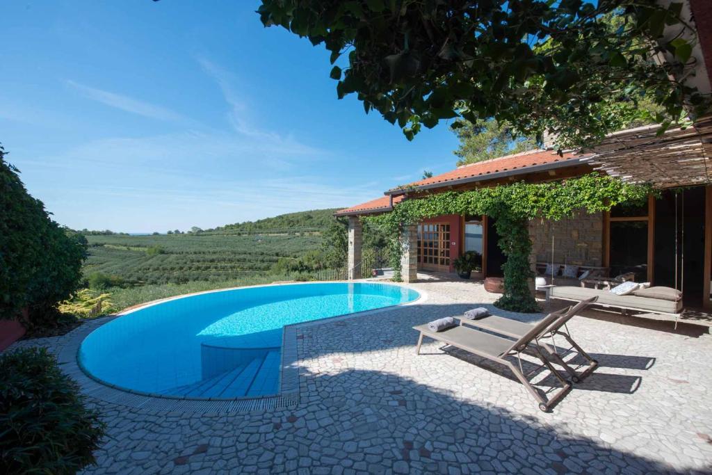 安卡蘭的住宿－Vila Petra，一个带椅子和房子的游泳池