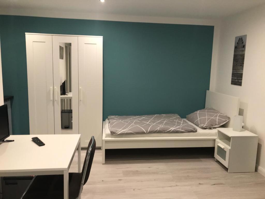 a bedroom with a bed and a blue wall at ALC Zimmervermietung in Brande-Hörnerkirchen