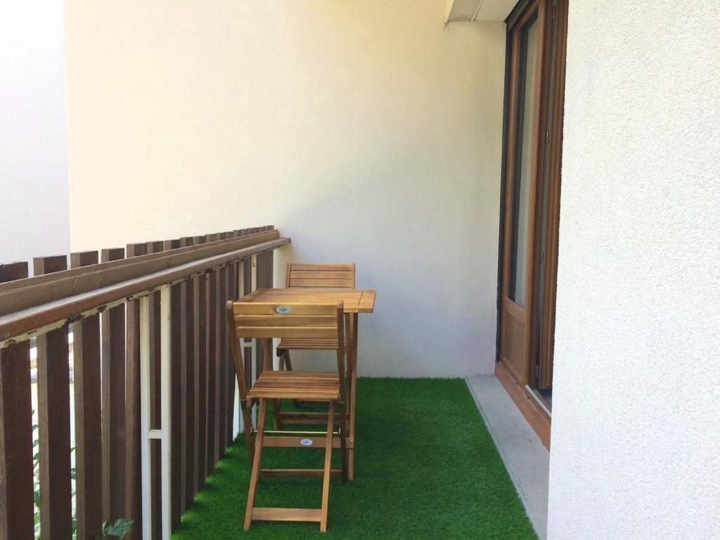 a desk and two chairs sitting on a balcony at Appartement d&#39;une chambre avec balcon amenage et wifi a Briancon in Briançon