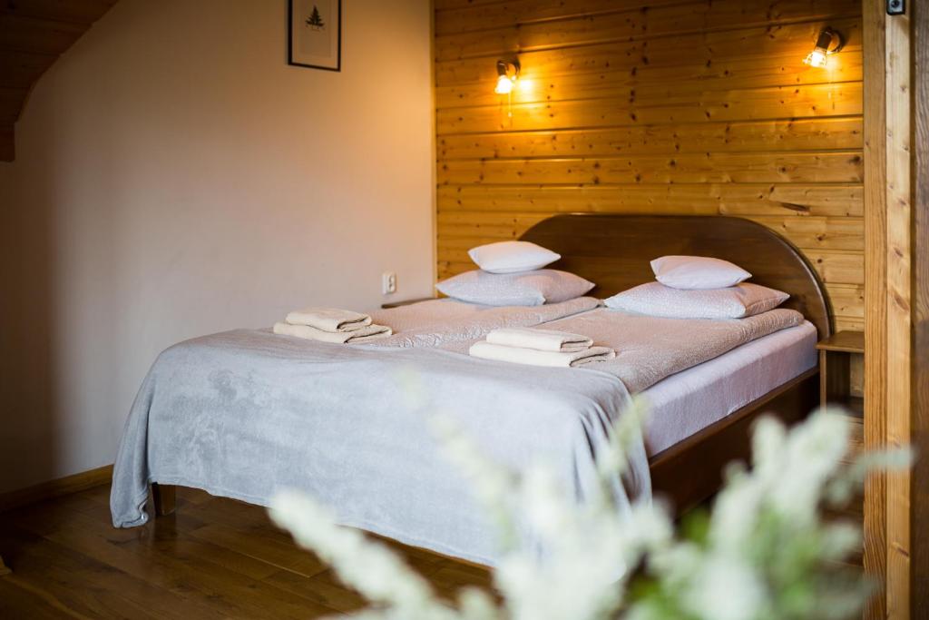 Niemczukówka 2 - Smerek في سميريك: غرفة نوم بسرير ذو شراشف ووسائد بيضاء