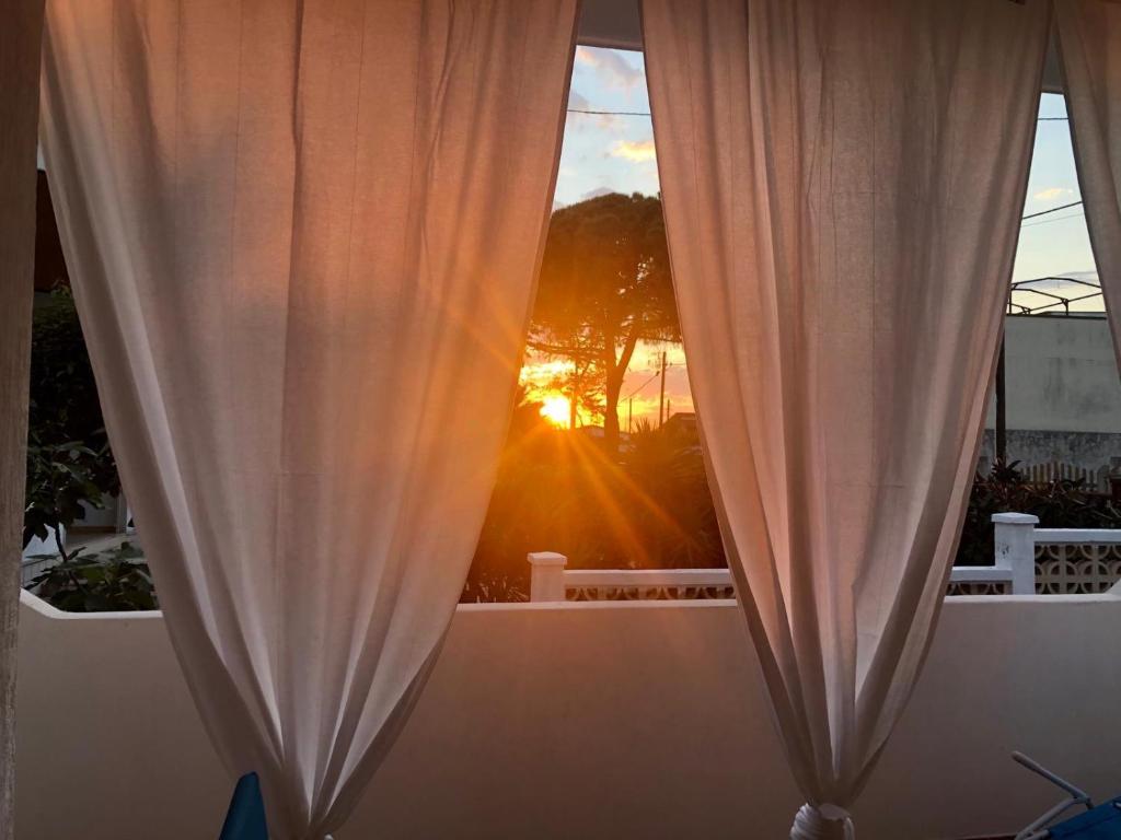una finestra con tenda e vista sul tramonto di Salento Sunset House a Pulsano