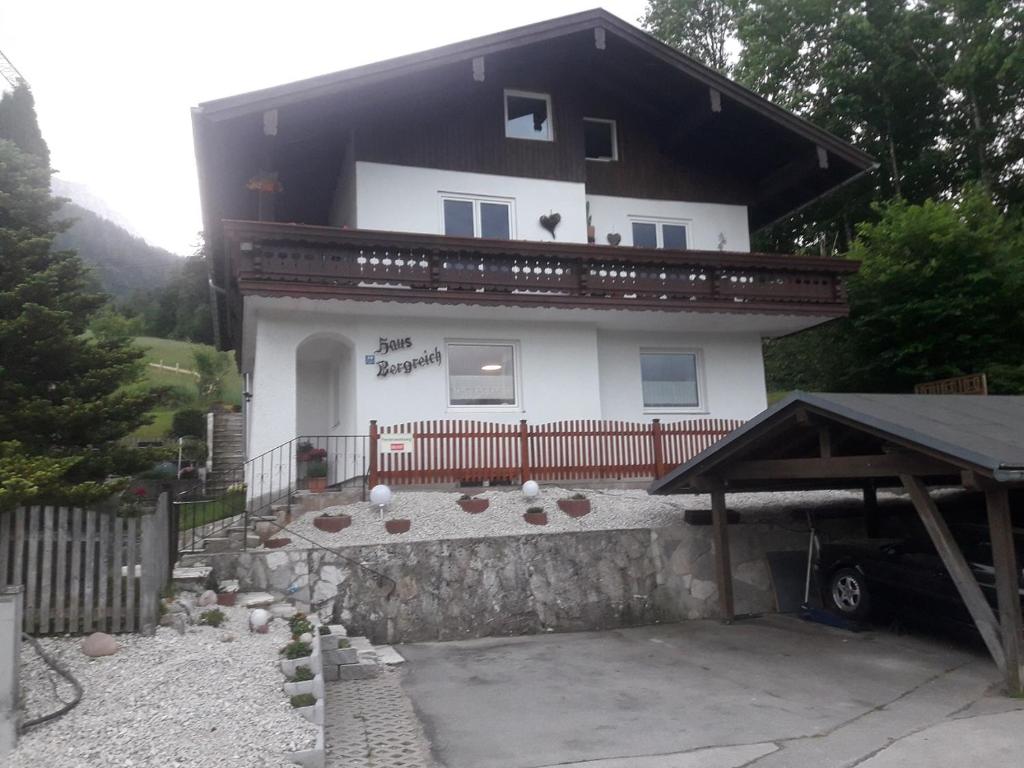 een groot wit huis met een hek en een tuin bij Haus Bergreich in Schönau am Königssee