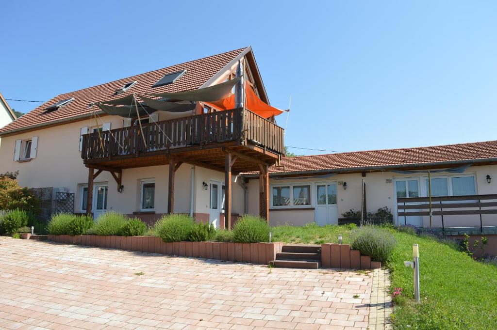 a house with a balcony and a patio at Chambres d'hôtes Les vignes in Saint-Jean-Saverne