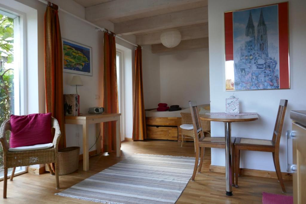 sala de estar con mesa, sillas y escritorio en Öko-Ferienwohnung-Kiel im Schwedenhaus, en Kiel