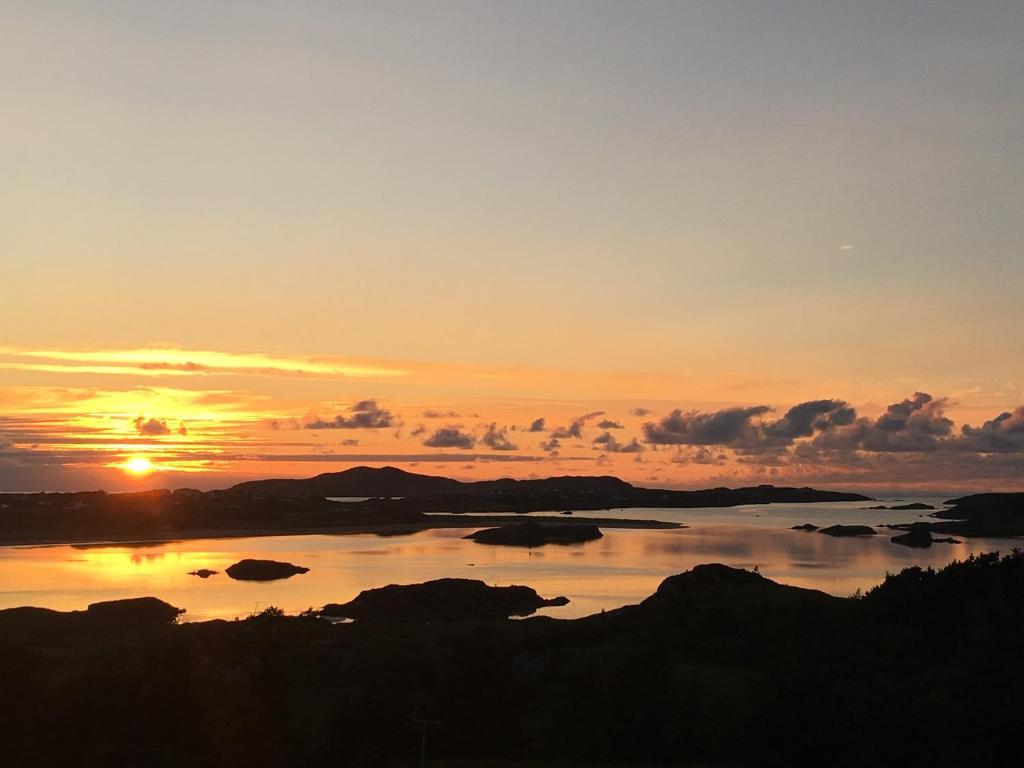 a sunset over a large body of water at Village Way Apartments in Kincasslagh