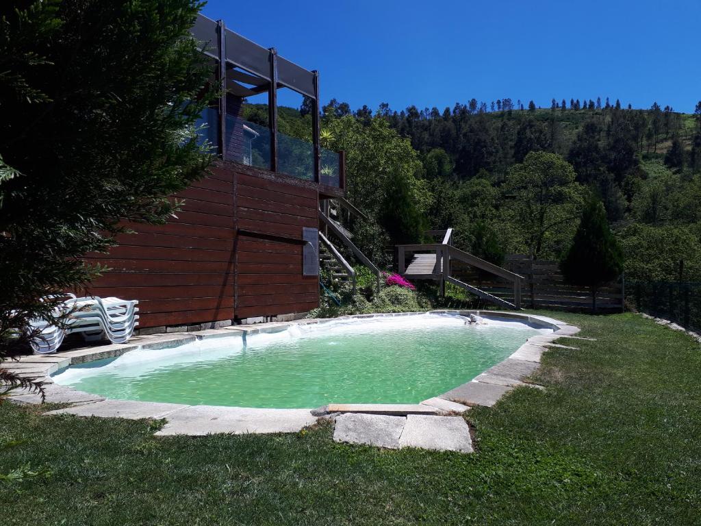 een zwembad in een tuin met een huis bij Fisgas Cabana in Bilhó