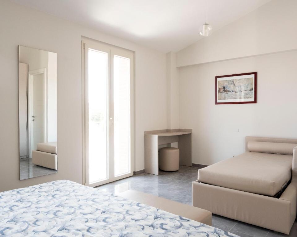 a bedroom with a bed and a couch and a mirror at Civico 43c in Porto San Giorgio