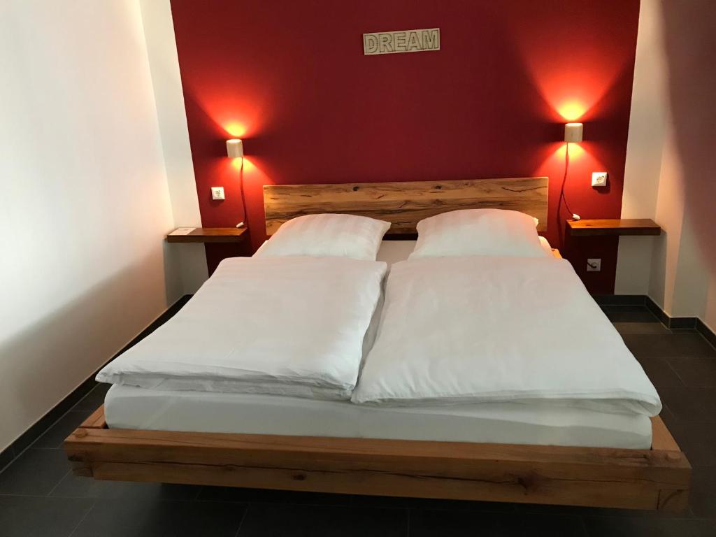 two beds in a room with red walls at Bobbele Freiburg Zentrum in Freiburg im Breisgau